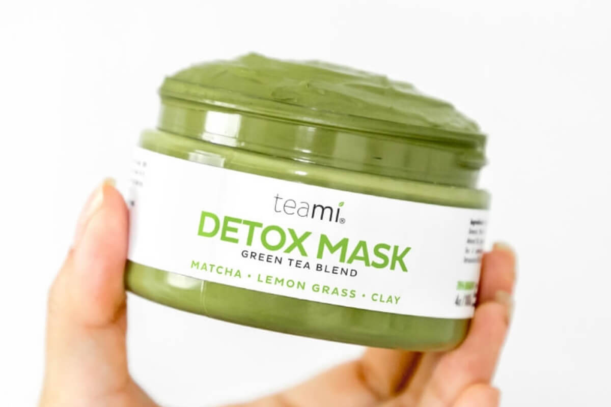 Hand holding Teami Detox Mash Green Tea Blend 