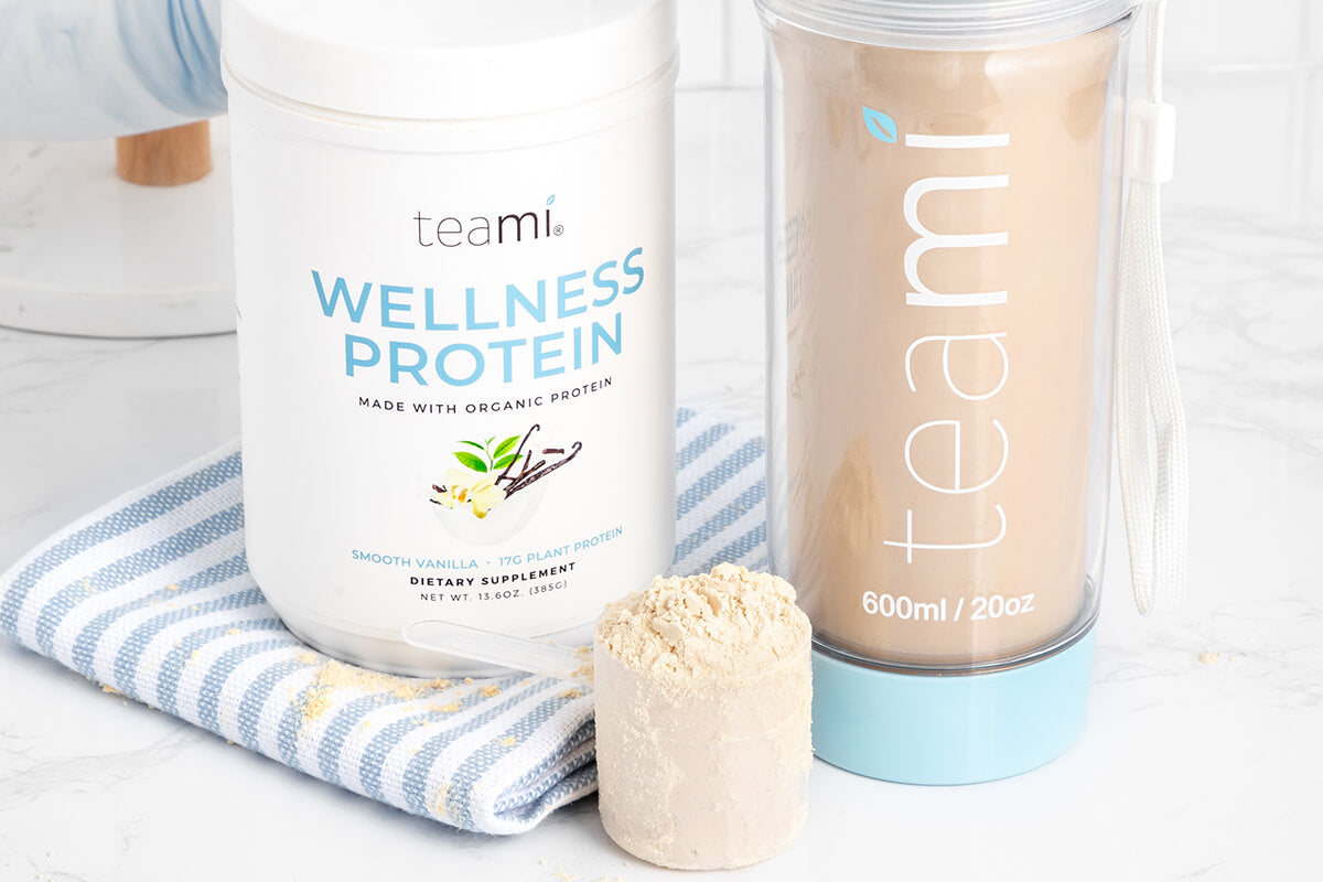 Tub of Teami Vanilla Wellness Protein, scoop and tea tumbler
