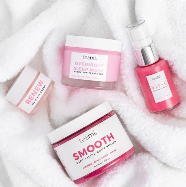 Teami Think Pink bundle products - overnight sleep mask, renew vit c cream, smooth body polish and vit c serum on towel