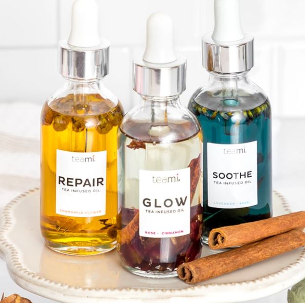 Teami repair, glow and soothe oils on surface with cinnamon sticks