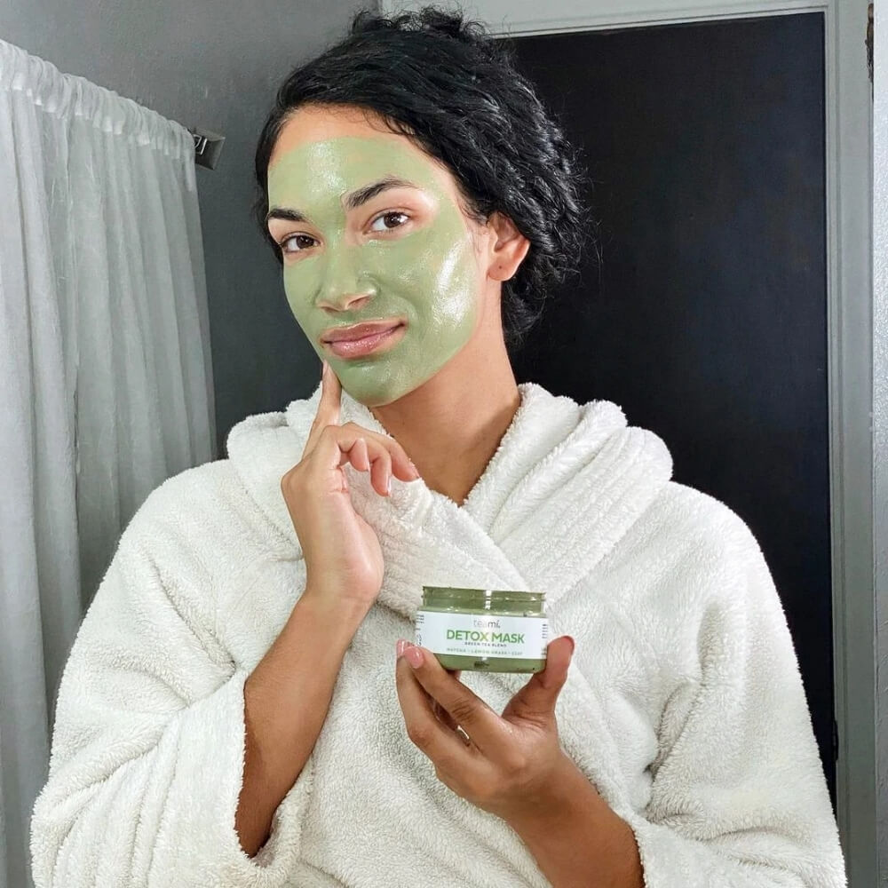 Woman applying Teami detox mask to her face