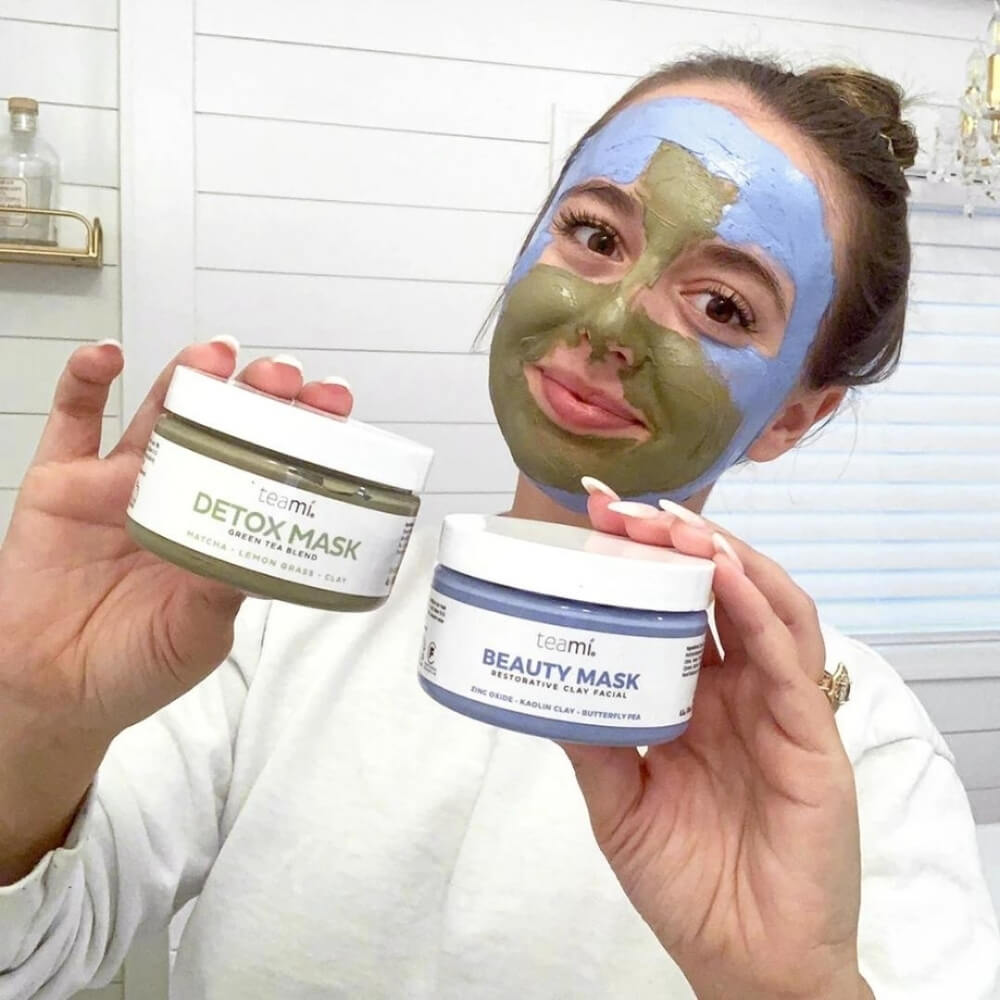 happy girl with detox mask and beauty mask on her face when showing the products in her hand