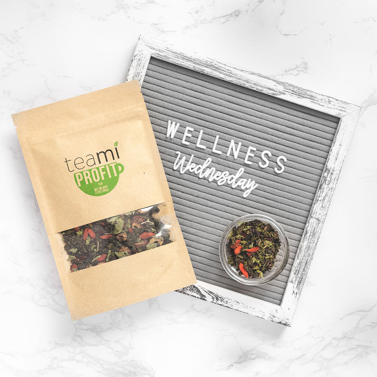 teami profit tea on kitchen counter with wellness wednesday sign