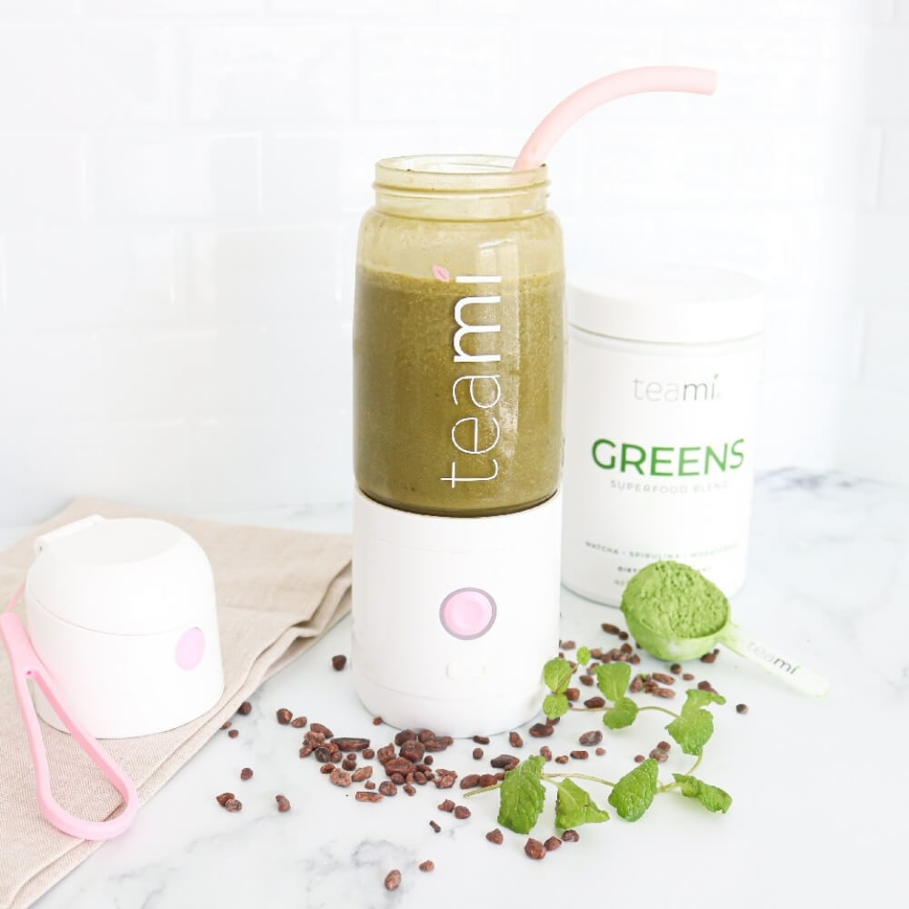 Teami MIXit portable blender in kitchen with lid off and containing Teami greens superfood blend