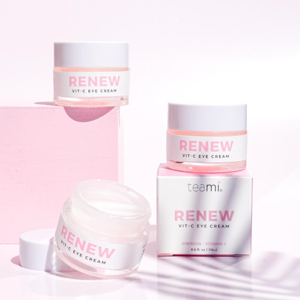 Multiple pots of Renew Vit C eye cream on pink background