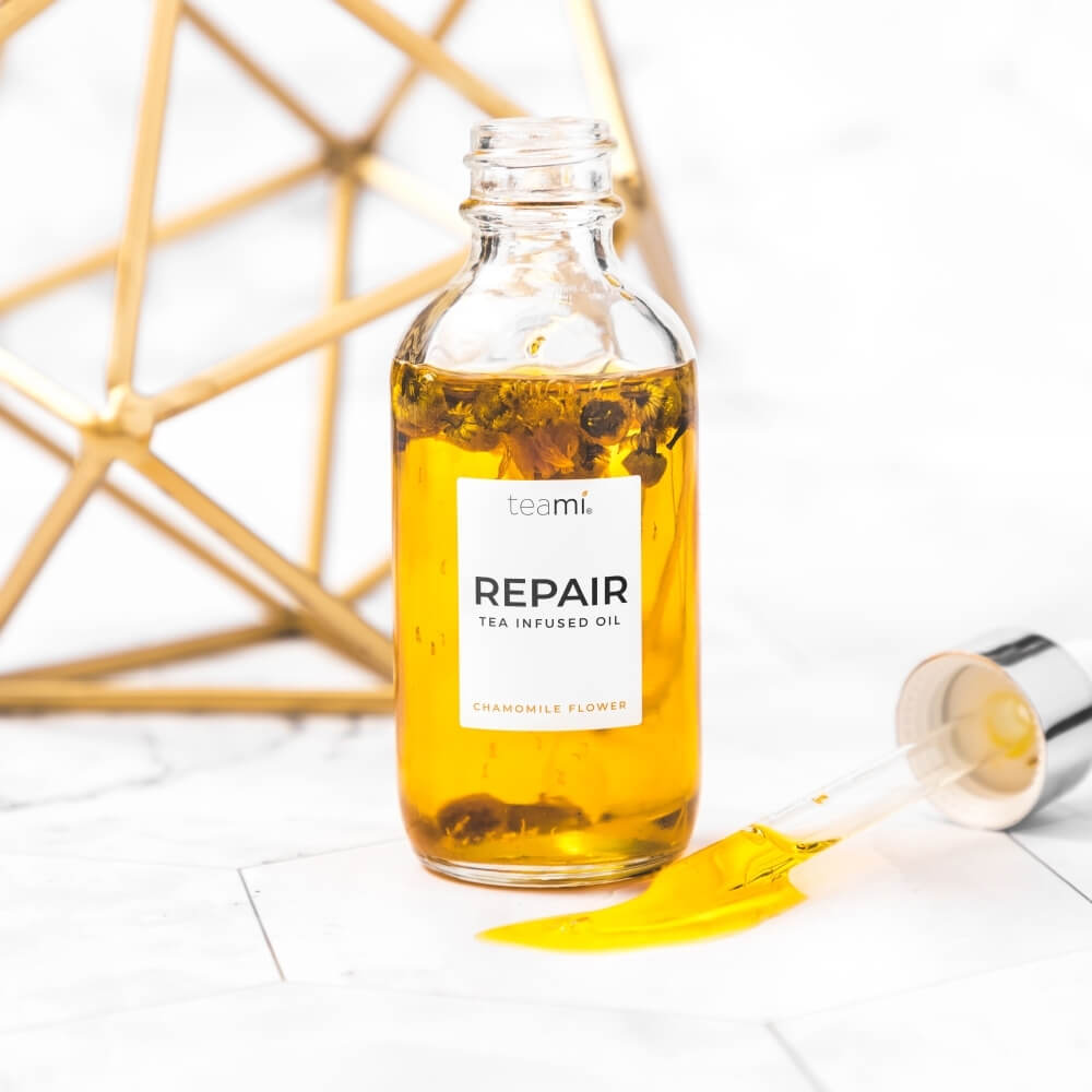 bottle of Teami repair oil with open lid on white background