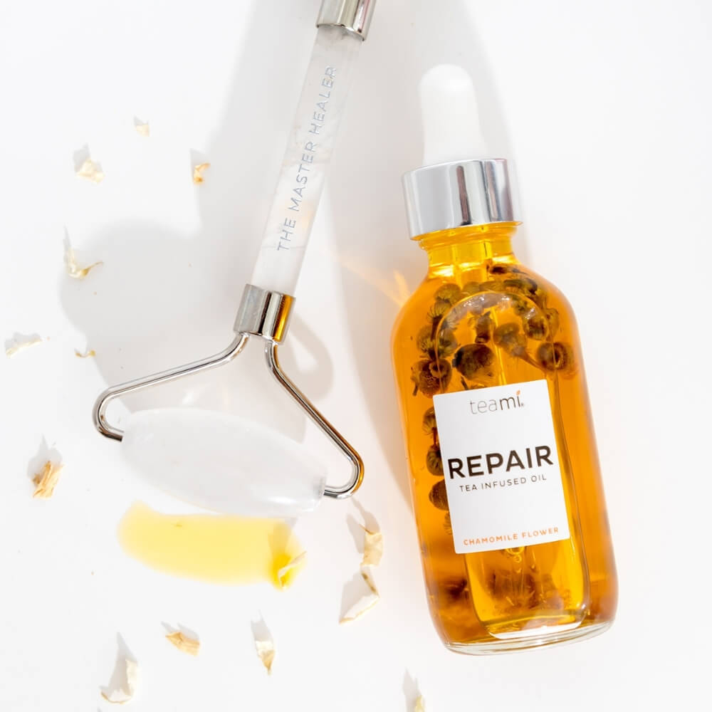 bottle of Teami repair oil with facial roller