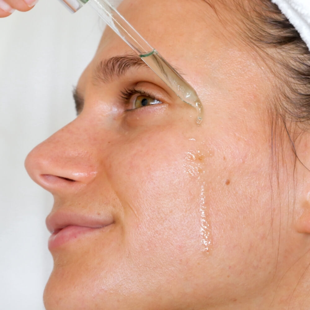 Women applying Teami soothe oil to her face
