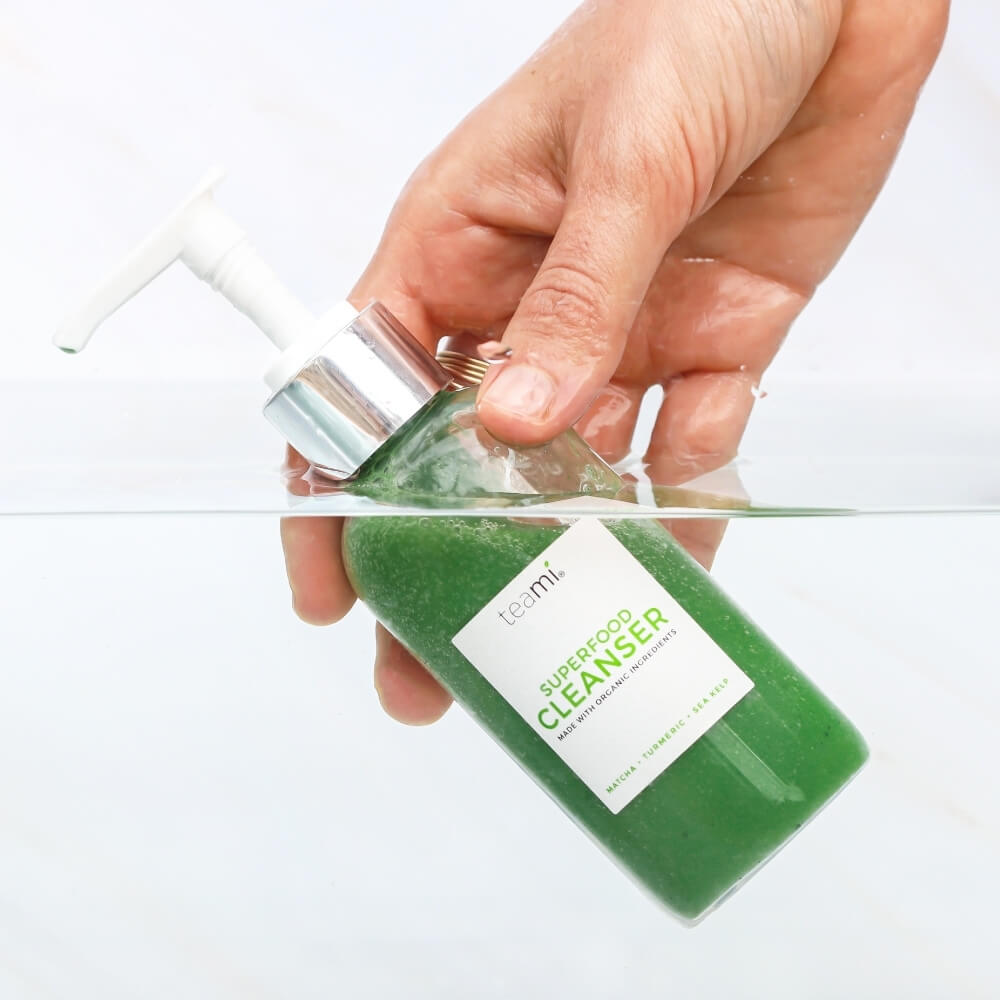 hand holding bottle of Teami superfood liquid cleanser in water
