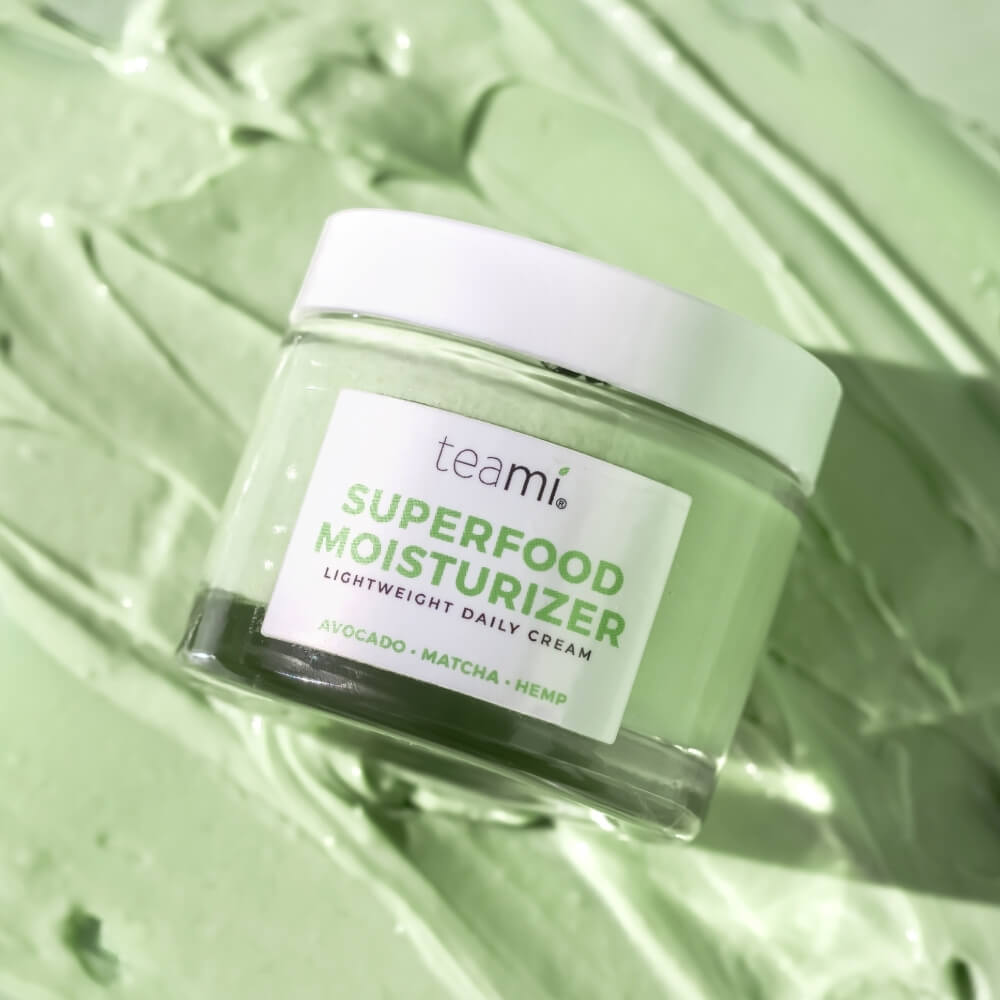 Teami superfood moisturizer cream laying on green background