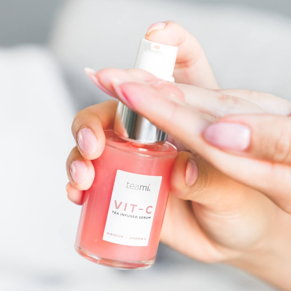 Person with pink nails pumping Teami hibiscus infused vit c serum onto their fingers
