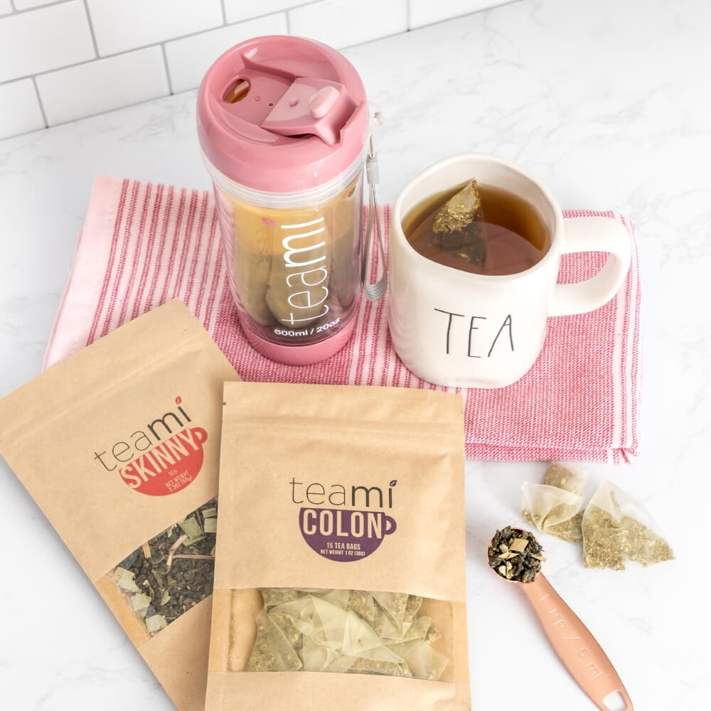 teami skinny tea and teami colon tea on a kitchen counter next to a tea tumbler and mug