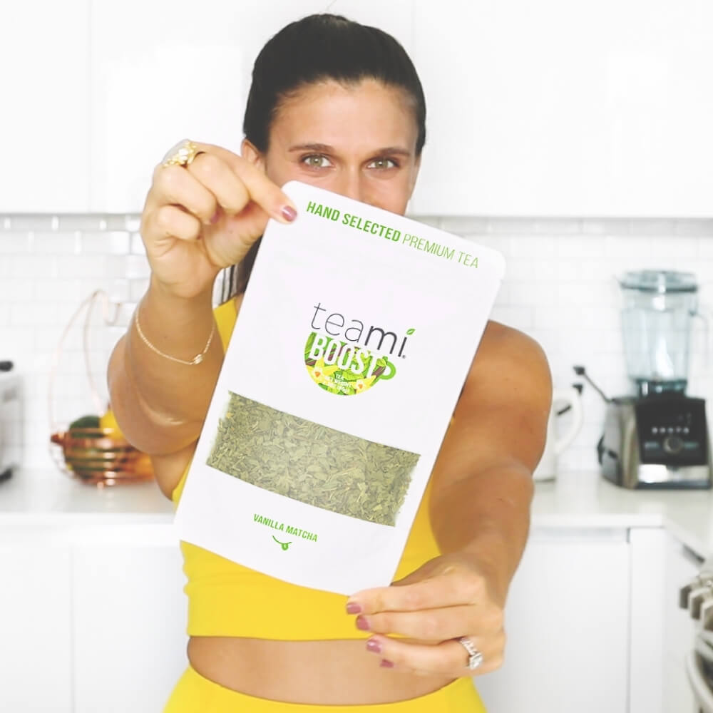woman holding pack of Teami boost tea