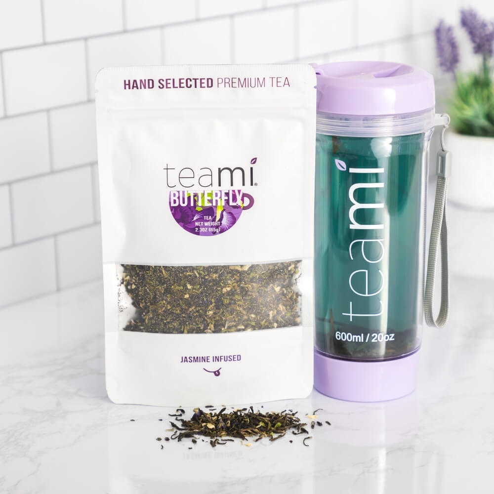 teami jasmine infused butterfly tea next to teami tumbler on a marble counter