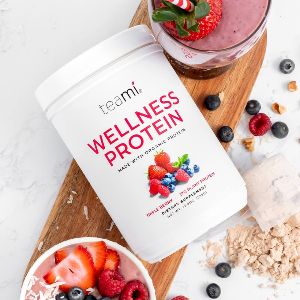 Tub of Teami wellness protein triple berry flavour lying on kitchen counter