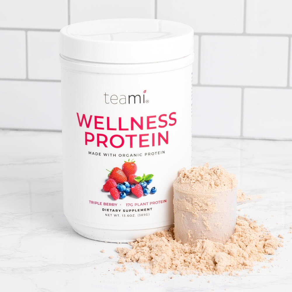 Tub of Teami wellness protein triple berry flavour on kitchen counter with scoop