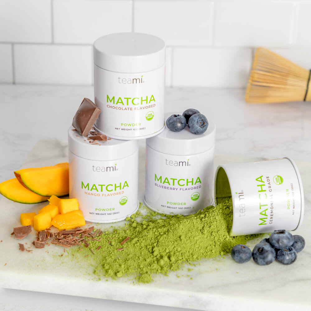 tubs of Teami wellness matcha powders on kitchen surface with ingredients