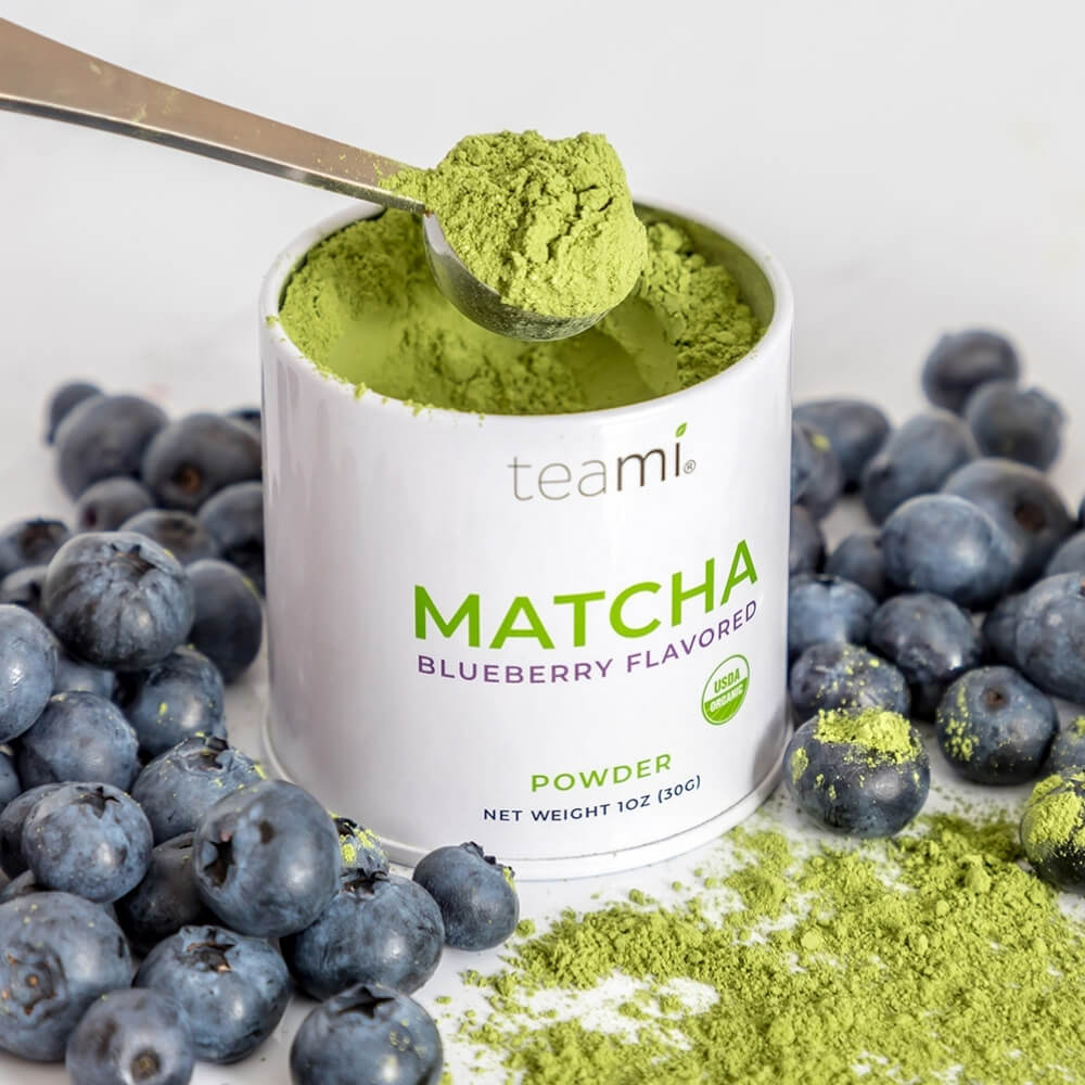 tub of Teami wellness matcha powder blueberry flavour on kitchen counter with blueberries 