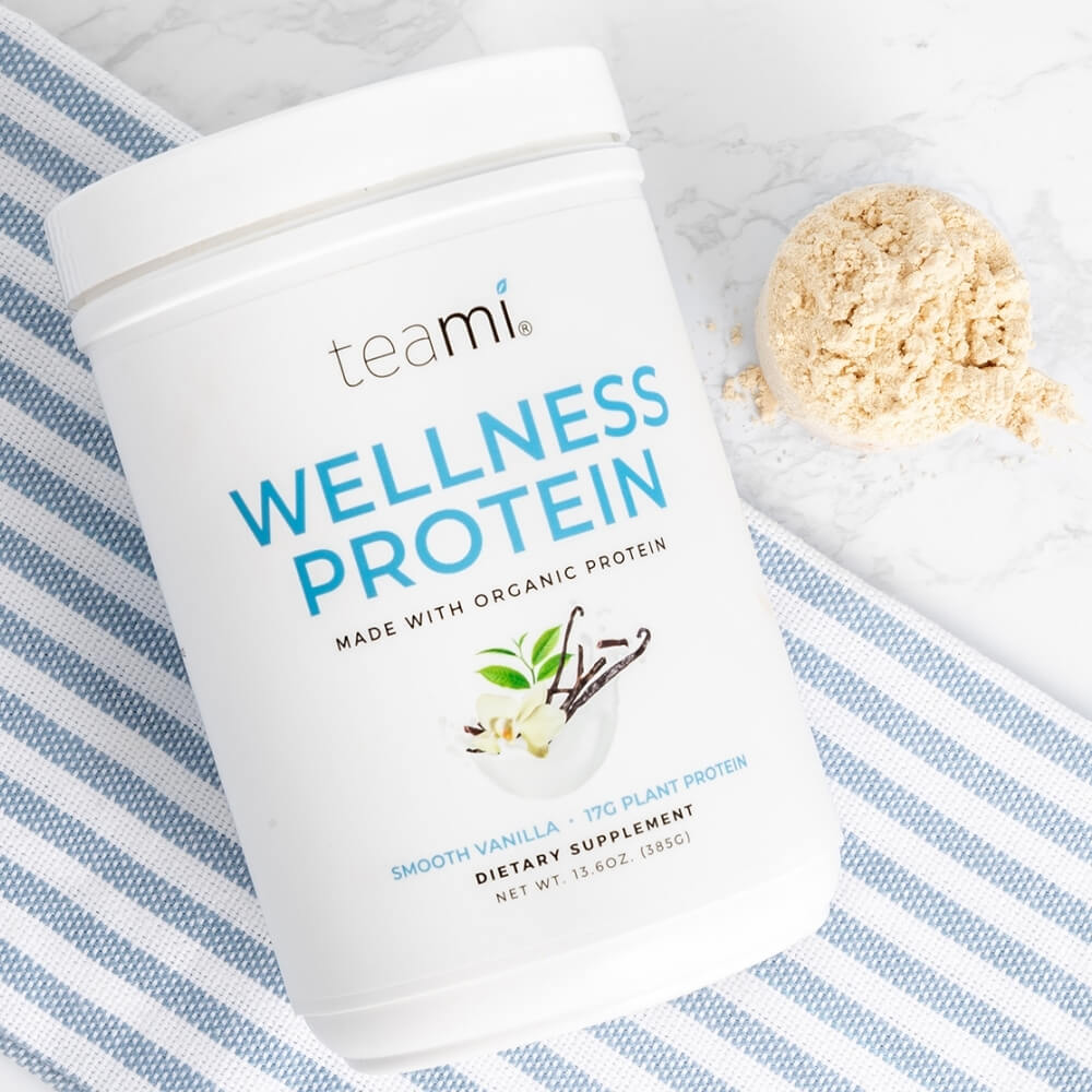 tub of teami wellness protein smooth vanilla flavour next to full scoop of protein