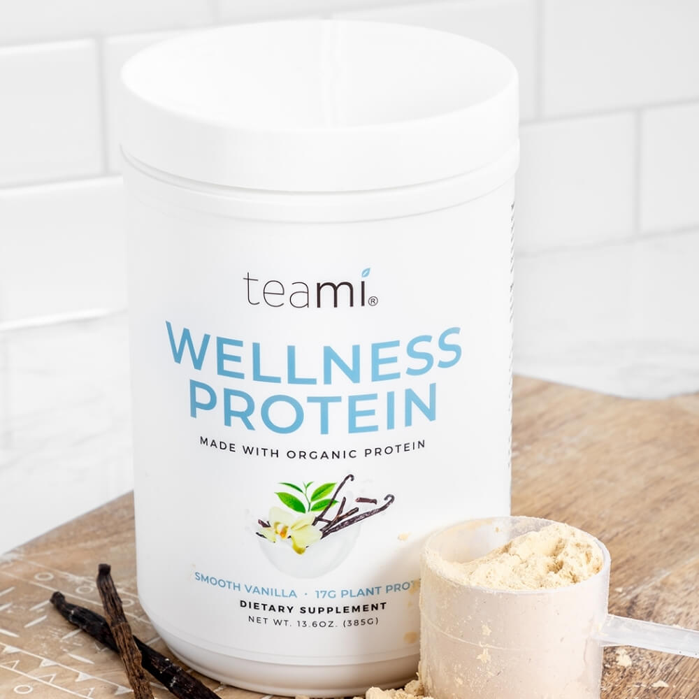 tub of teami wellness protein smooth vanilla flavour in kitchen with scoop